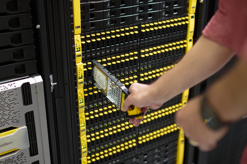 Close-up of man in server room looking at 3PAR server racks